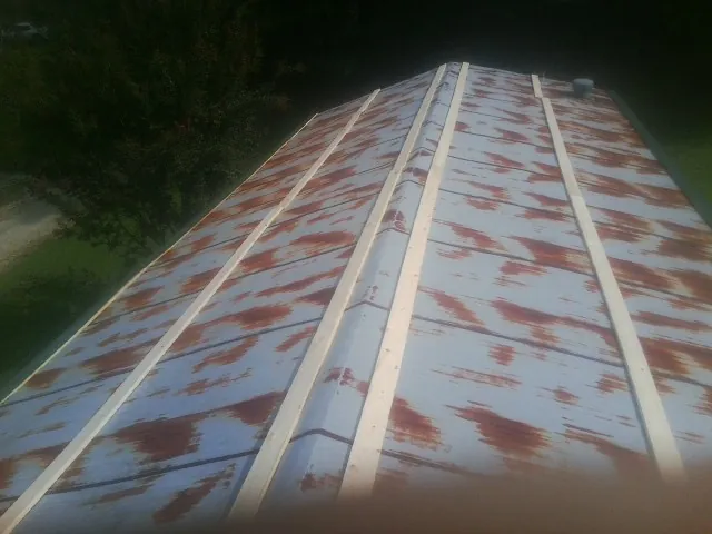 Rusted metal roof panels with new wood purlins before replacement — Storm Damage Roof Repair in Emerald Isle by Roofing Brothers