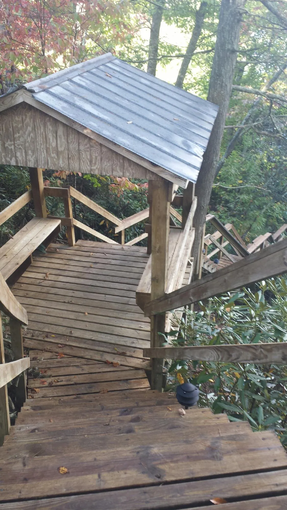 Metal roofed shelter over wooden steps on a wooded walkway — Skylight Repair & Installation work by our crew in Emerald Isle
