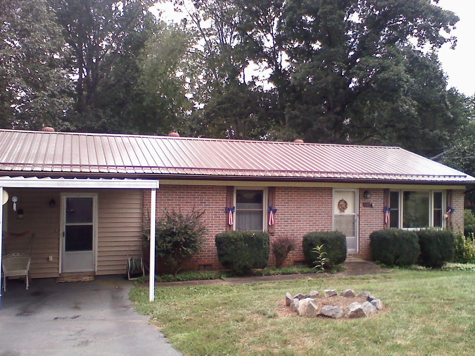 Bronze metal roof and carport on a brick ranch home — Roof Repair work by our crew in Emerald Isle